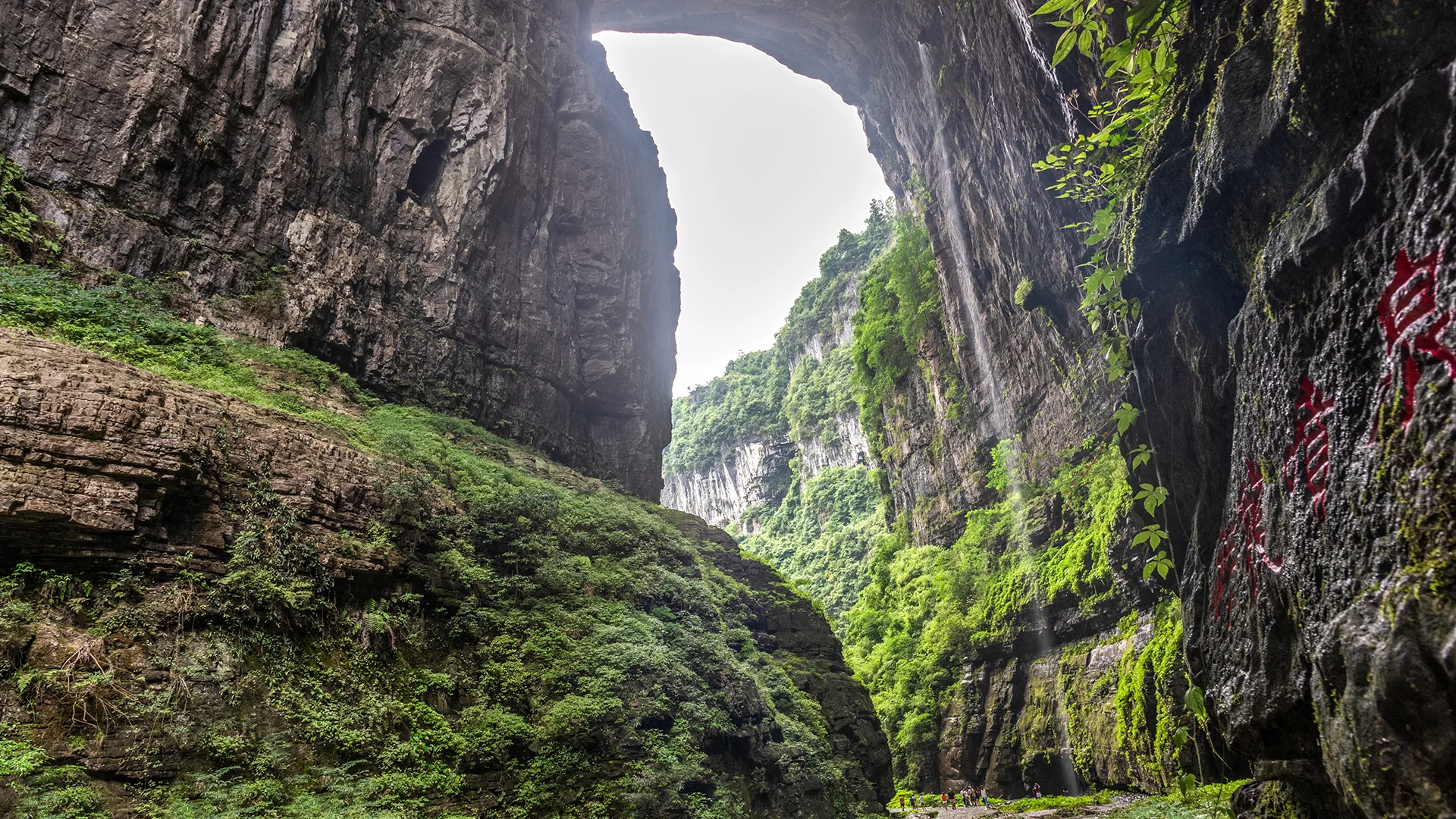 Pathway beneath a giant natural bridge at Wulong Karst Scenic Area