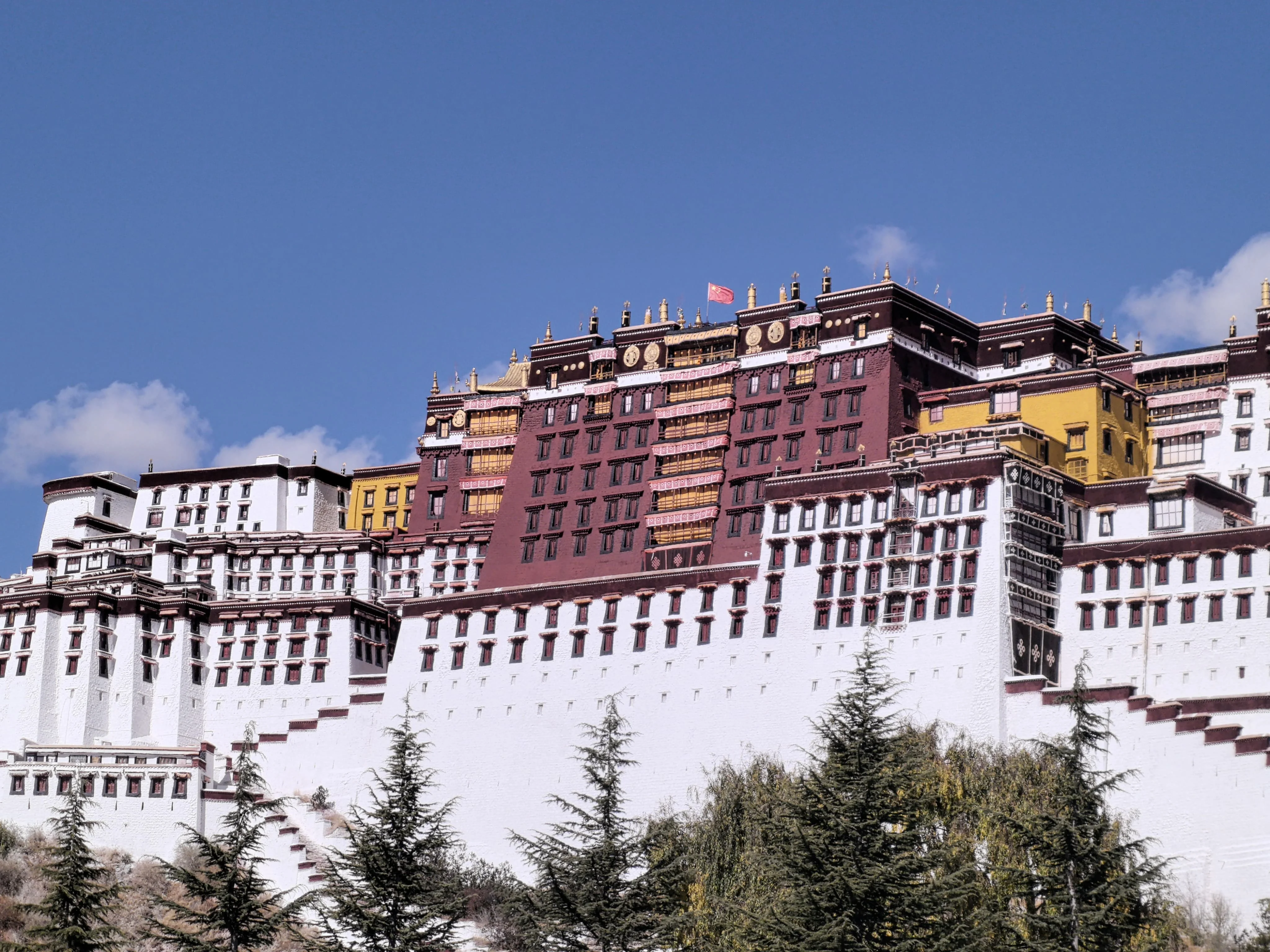 Potala Palace rising above Lhasa under a bright blue sky