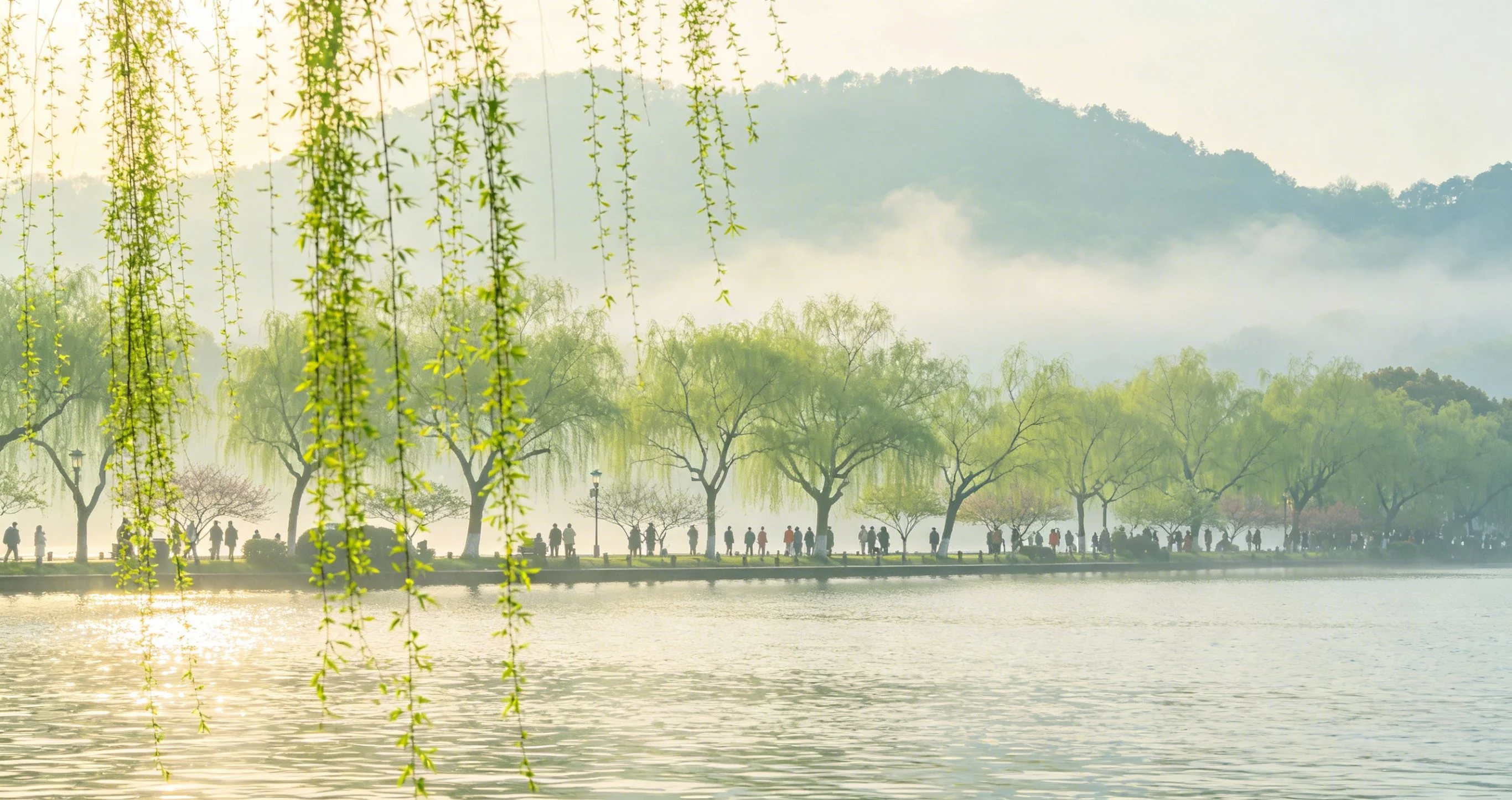 Su Causeway lined with willow trees and a lakeside path at West Lake, Hangzhou