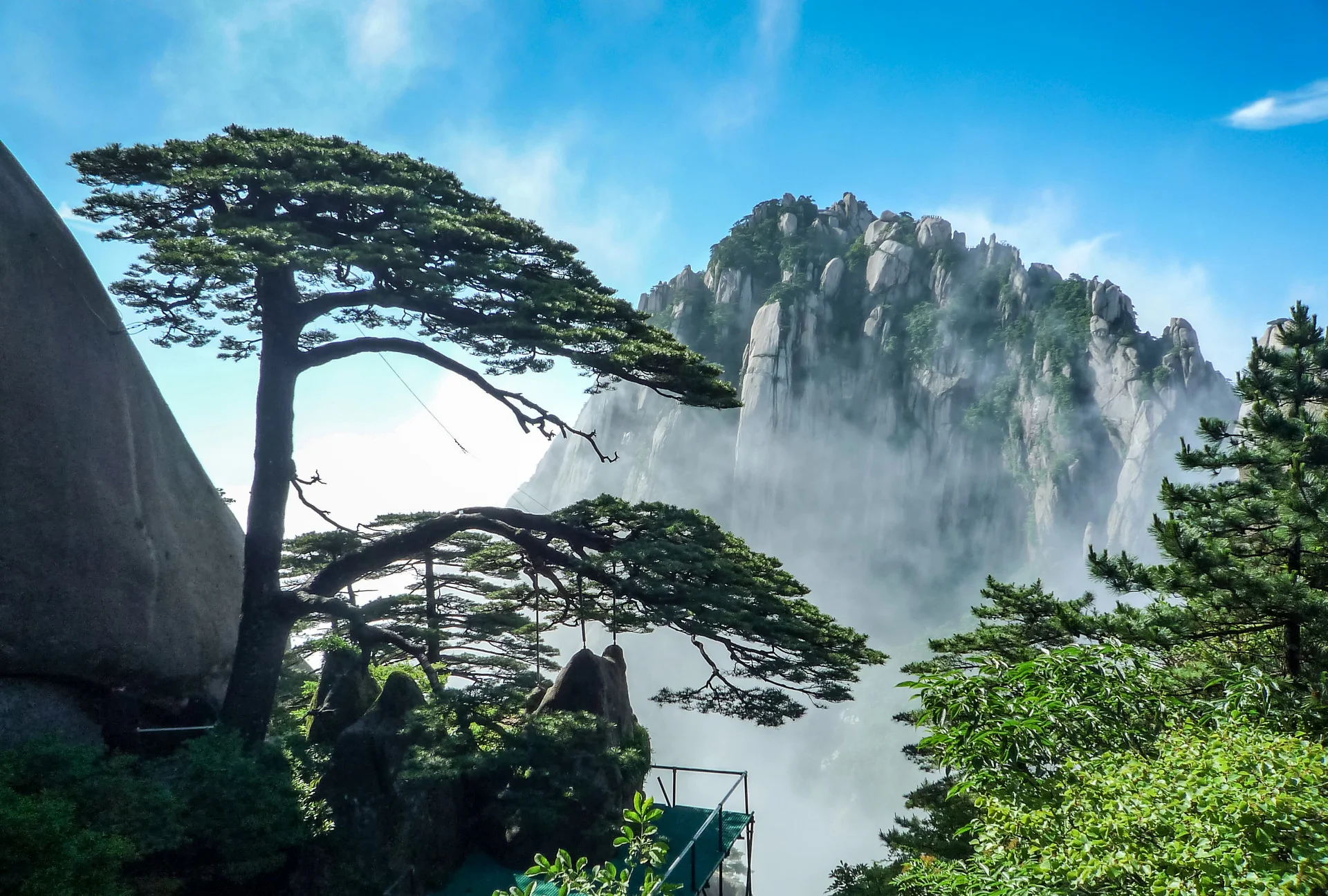 Panoramic view of China famous mountains with jagged peaks, clouds, and hiking trails