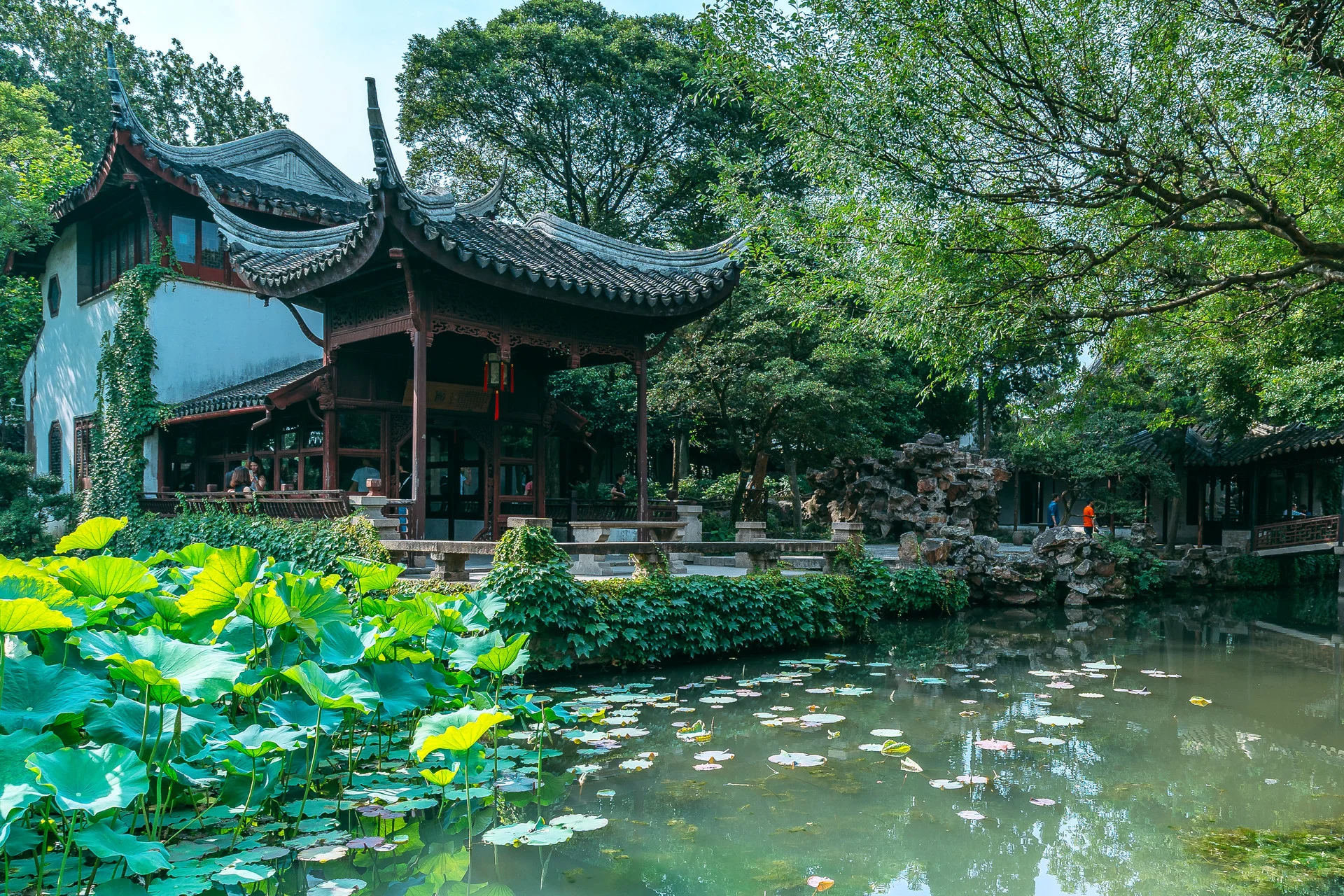 Panoramic view of a classical Suzhou garden with pond, pavilions, and rockeries