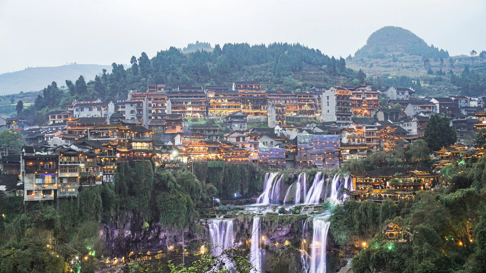 Panoramic banner of Fenghuang Ancient Town riverside houses and bridges at dusk