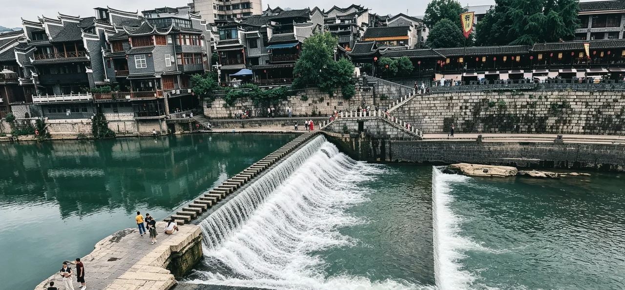 Riverside view of Fenghuang Ancient Town with Tujia-style houses and boats
