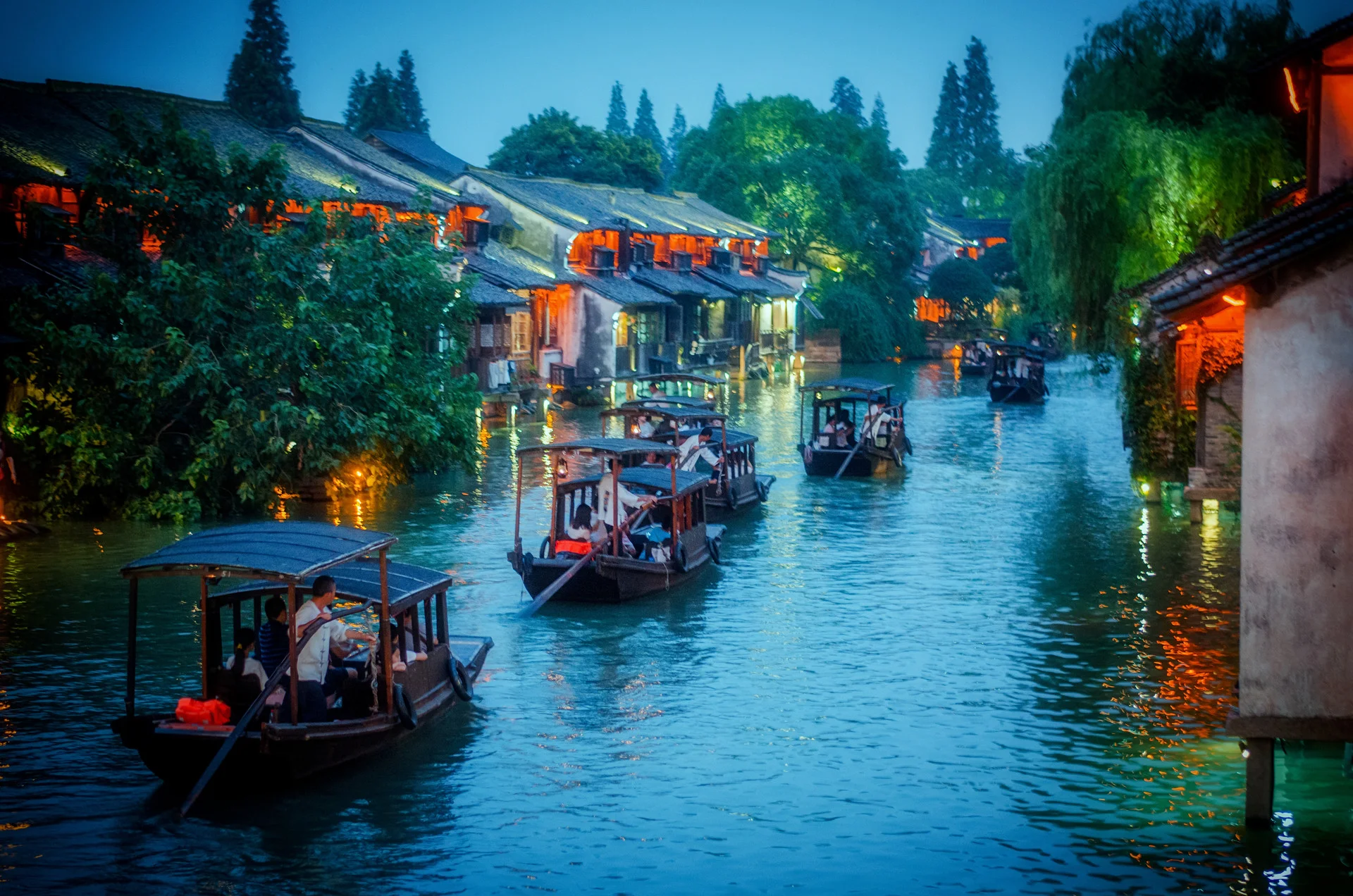 Ancient Jiangnan canal town with arched bridge, willow trees, and traditional waterside homes