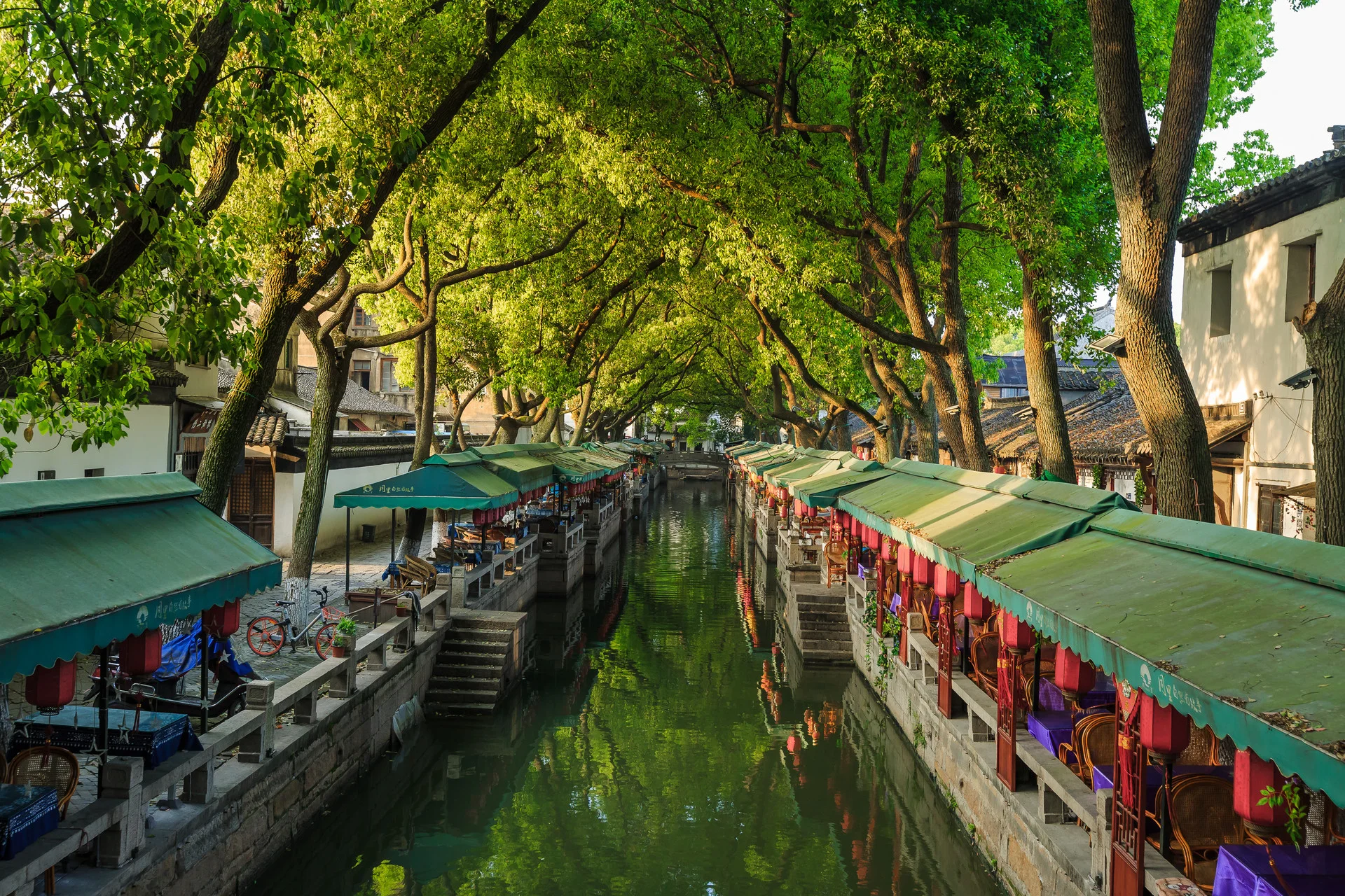 Stone bridge over a quiet canal in an ancient Jiangnan town with traditional black-tiled houses