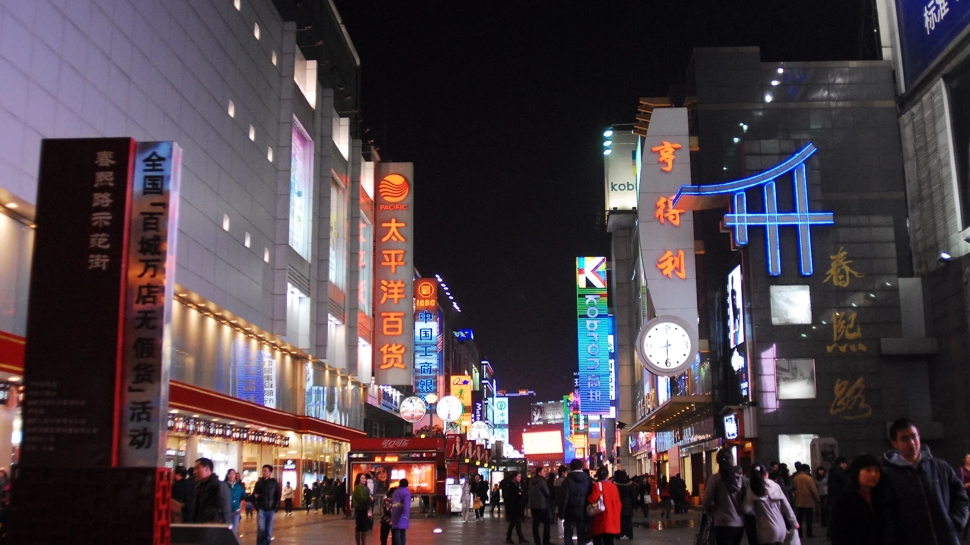 Bustling shopping street in Guangzhou with fashion stores and neon signs