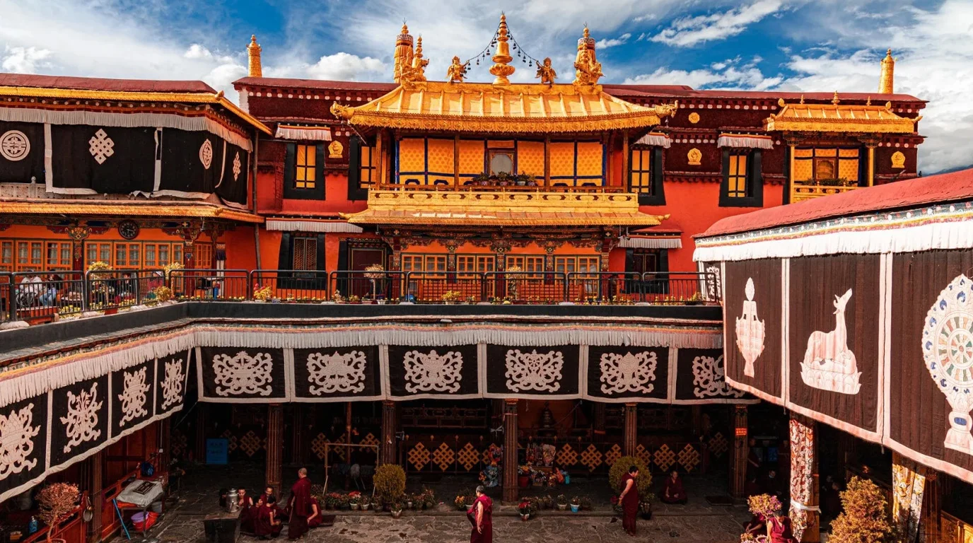 Panoramic view of a Tibetan monastery in Lhasa with prayer flags and mountain backdrop